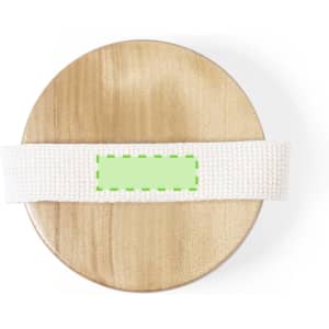 A round wooden surface with a white textured strap laid across it, featuring a green label in the centre.