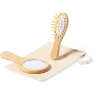 A bamboo hairbrush and mirror set on a cream fabric pouch, featuring a simple design and natural tones.