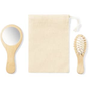 A wooden mirror and brush set, accompanied by a natural fabric pouch, displayed together for a beauty kit.