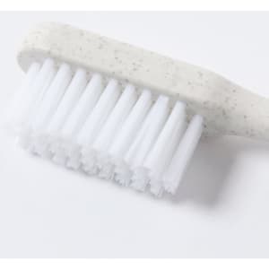 A toothbrush with a speckled grey handle and white bristles, featuring a logo on the handle.