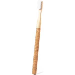 A natural bamboo toothbrush with a cork handle and white bristles. It features a simple design and branding.