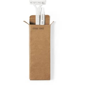 A shaving kit set in a brown box, featuring a razor and shaving cream tube. The box has a logo.