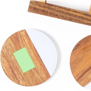 A set of wooden coasters in circular shapes, featuring a mix of natural wood tones and a green accent.