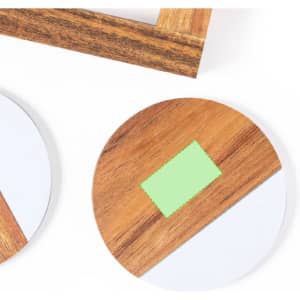A set of round wooden coasters with a light-coloured base and a green accent. The image includes a wooden holder.
