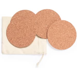A set of four round cork coasters displayed alongside a natural fabric storage pouch.