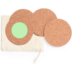A set of four cork coasters, with one featuring a green centre, packaged in a cream drawstring bag.