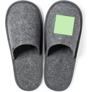 A pair of grey slippers with a green square patch. The slippers feature a soft, felt-like texture.