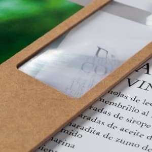 A brown bookmark with a transparent magnifying section, positioned over printed text and a green background.
