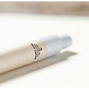 A pen with a recycled milk carton body and a silver tip, featuring a logo on the side.