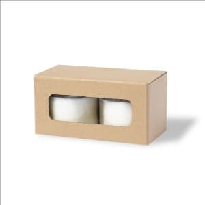 A box containing two white aromatic candles, enclosed in clear packaging. The outer box is brown cardboard.
