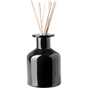 A black aromatic diffuser with wooden reeds on top in a sleek, minimalist design.