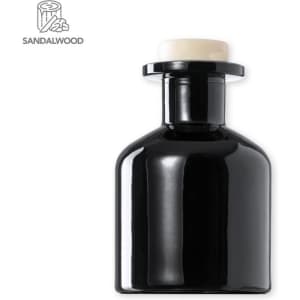 A black aromatic diffuser with a cream-coloured top, featuring a logo design on the left.