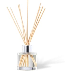 A fragrant diffuser with wooden reeds in a clear glass container and a silver top, set against a white background.