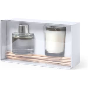 A scented diffuser and a candle in a clear box with wooden sticks, featuring a silver cap and white candle.
