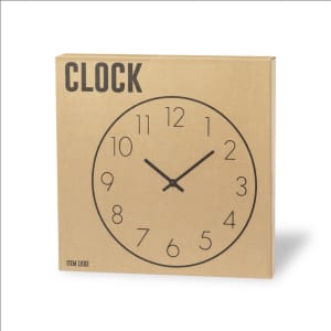 A wall clock featuring a simple black face with numbers and hands on a brown cardboard packaging.