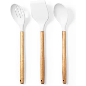 Set of three kitchen utensils featuring white heads and wooden handles. Includes a slotted spoon, spatula, and regular spoon.