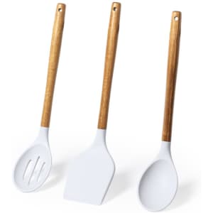 A set of three kitchen utensils with white silicone heads and wooden handles, including a slotted spoon, spatula, and ladle.