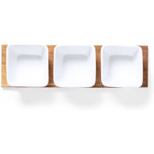A wooden serving tray with three square white ceramic bowls arranged in a row.