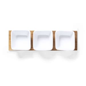 A wooden serving tray with three square white dishes arranged in a row. The tray has a natural finish.