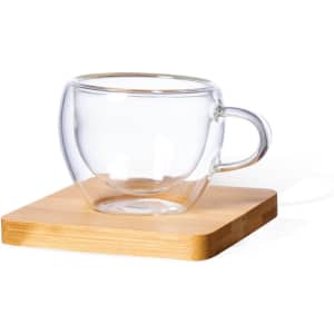 A clear glass mug sits on a wooden coaster, showcasing its elegant design and transparent appearance.
