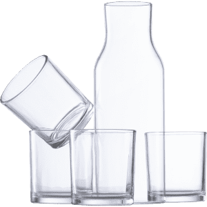 A drink bottle and three glass tumblers in clear glass, arranged with one tumbler tilted.