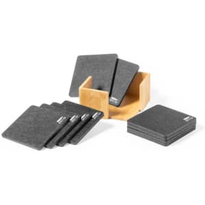 A set of dark grey coasters displayed next to a wooden storage box, featuring a logo on the coasters.