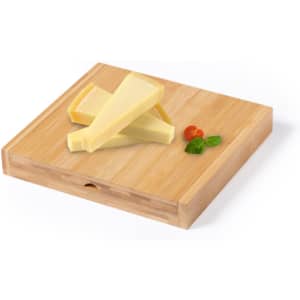 A bamboo cheese board with three slices of yellow cheese and small sprigs of green herbs.