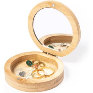 A bamboo jewellery wrap featuring a mirror, containing assorted rings and earrings inside.