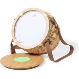 A round, woven thermal picnic basket in natural tones with brown straps, featuring a solid lid.