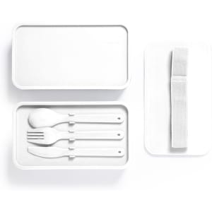 A white lunch box with a removable lid and a soft strap, containing a spoon, fork, and knife.