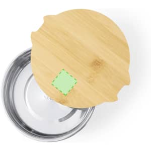A bamboo lid atop a stainless steel lunch box, featuring a small green label on the lid's surface.