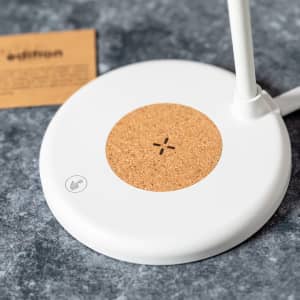 A multifunction lamp featuring a white base with a cork centre, designed for wireless charging.