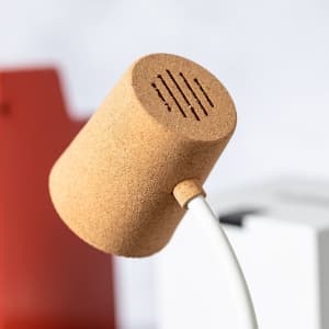 A multifunction lamp with a cork finish, featuring a rounded shade and an attached white cord.