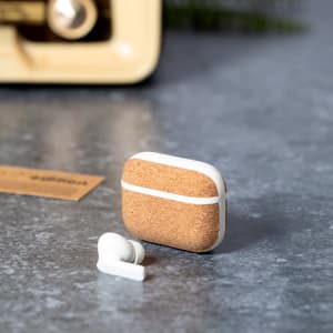 Crawly Earphones in a cork case, featuring white accents and a single earbud beside it on a textured surface.