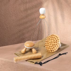 A set of natural wooden massage tools including a handheld massager, a spiked disc, and a rolling stick, in a fabric pouch.