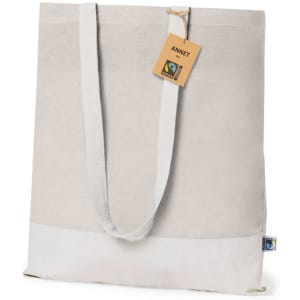 A beige tote bag with a light grey bottom and long handles, featuring a logo and a tag.