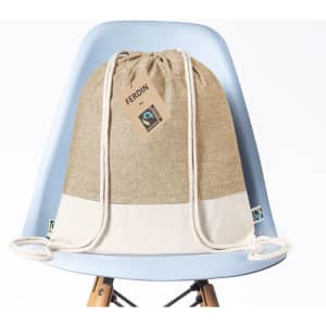 A tan and cream drawstring bag displayed on a blue chair, featuring a tag and a logo.
