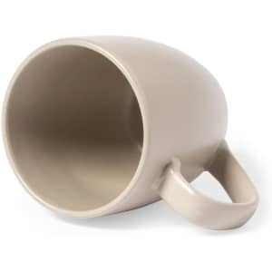 A coffee mug in a light beige colour with a curved shape and a handle, featuring a simple design.