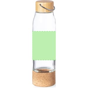A drink bottle made of clear glass with a cork base and a wooden cap, featuring a blank green label.