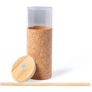 A cylindrical glass cup with a cork base, wooden lid, and a bamboo straw, featuring natural tones.