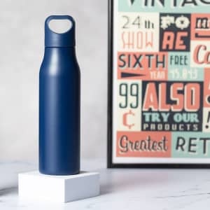 A drink bottle in a sleek navy blue finish with a handle and a branding logo displayed nearby.