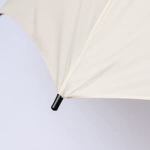 A Tinnar XL umbrella in cream with a black tip, featuring a sleek, simple design and a logo.