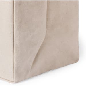 A beige tote bag with a soft fabric texture, featuring a stitched design and subtle branding.