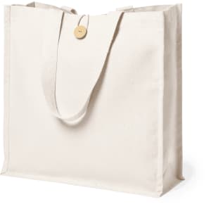 A cream-coloured tote bag with long handles and a button detail, featuring a simple design and a logo.