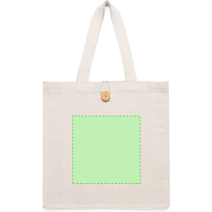 A cream tote bag featuring a green square design area, with two handles and a wooden button closure.