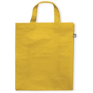 A yellow reusable grocery bag with two handles and a small logo tag on the side.