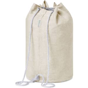 A drawstring duffel bag in a light beige fabric with grey drawstrings and a logo.