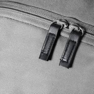 A grey backpack featuring a textured fabric and dual zippers. It has a logo on the exterior.