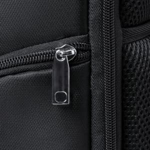 A close-up of a black backpack zipper and fabric, featuring textured material and a mesh section.