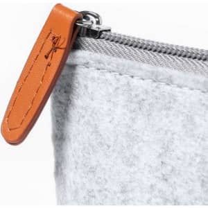 A grey felt pencil case with a brown leather zipper pull and a silver zipper. It features a branded logo.